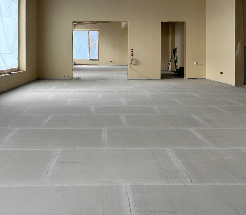 Innenansicht der Mensa im Neubau der Grundschule Hemmingen: NORIT-Trockenestrichplatten frisch verlegt, restlicher Bereich noch Baustelle. | © © www.Lindner-Group.com