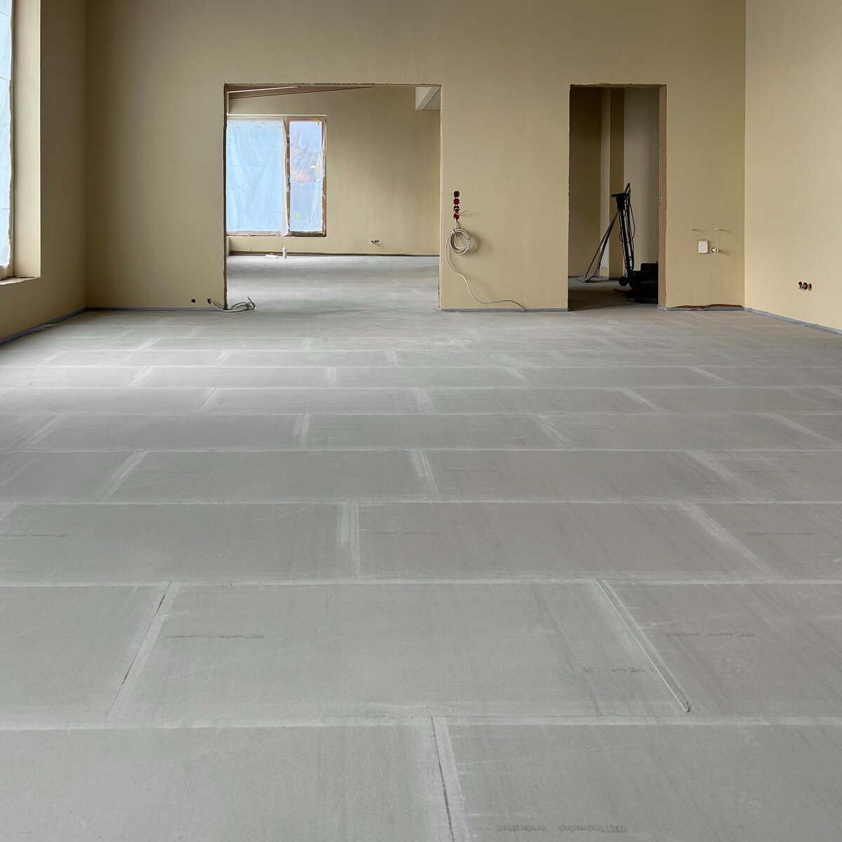 Innenansicht der Mensa im Neubau der Grundschule Hemmingen: NORIT-Trockenestrichplatten frisch verlegt, restlicher Bereich noch Baustelle. | © © www.Lindner-Group.com